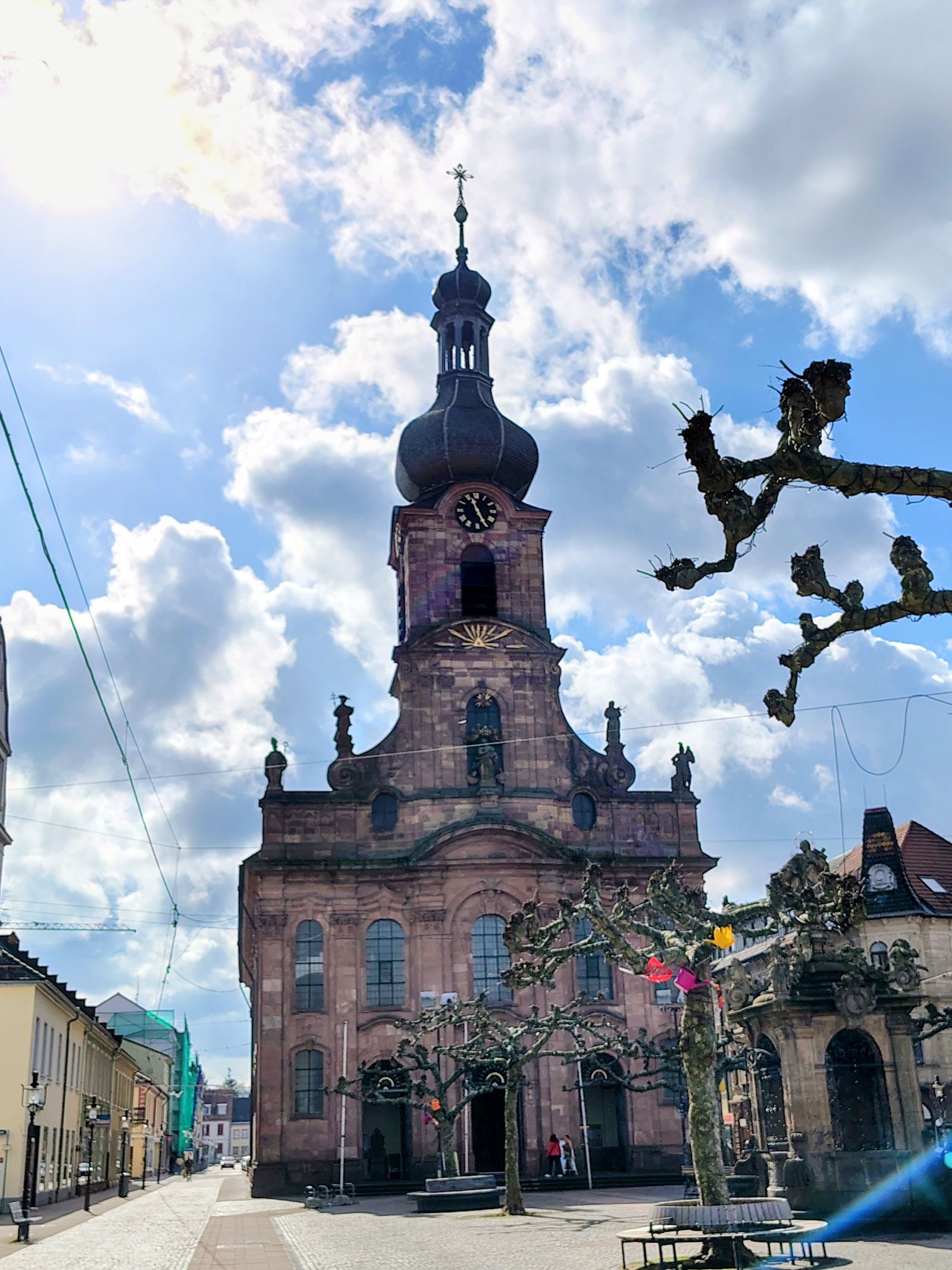 A baroque church tower over the old town, framed by the first blossom