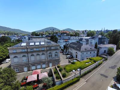 The spa quarter from above — rooftops, parkland and the forest closing the view