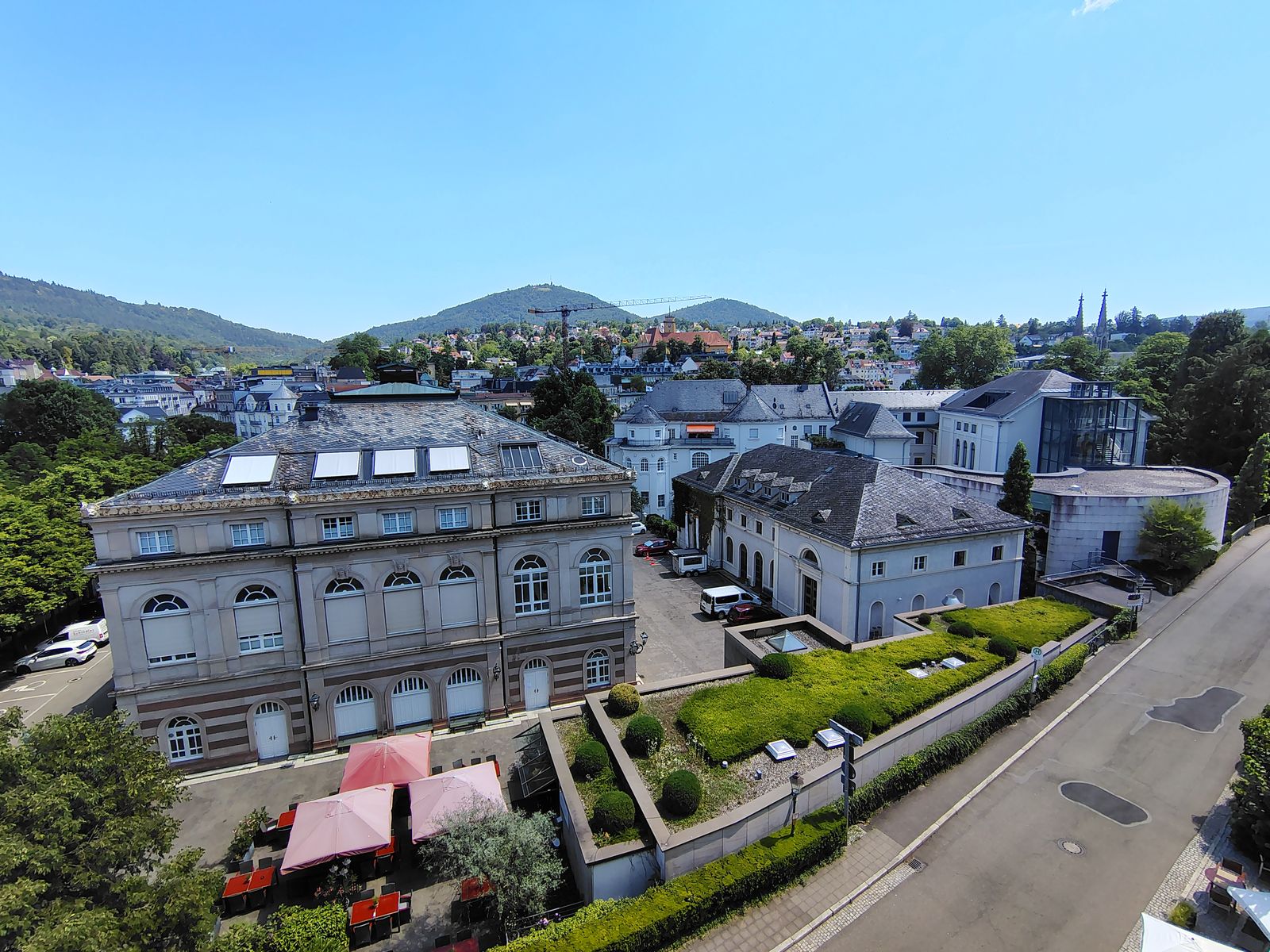 The spa quarter from above — rooftops, parkland and the forest closing the view