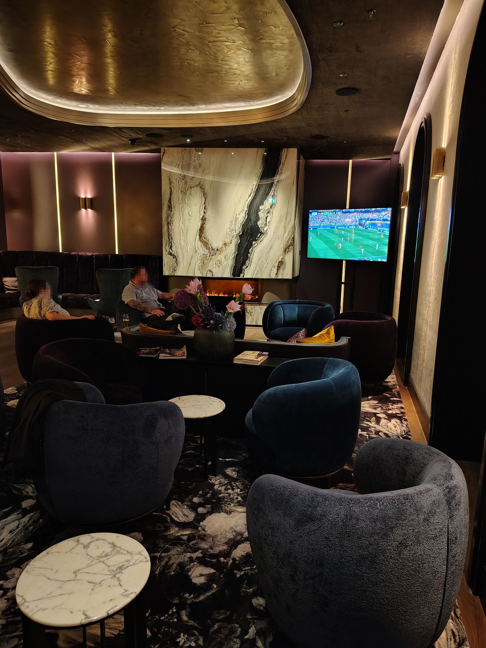 The lounge at the Steigenberger Icon Europäischer Hof — fire lit, football on, nobody in a hurry