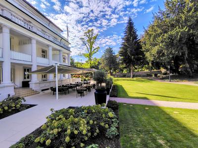 The Badischer Hof garden frontage on a bright morning, the lawn running down to the trees