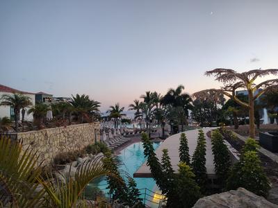 Dusk over the Lopesan Baobab gardens — pools stepping down towards the Atlantic, and a new moon over the whole thing
