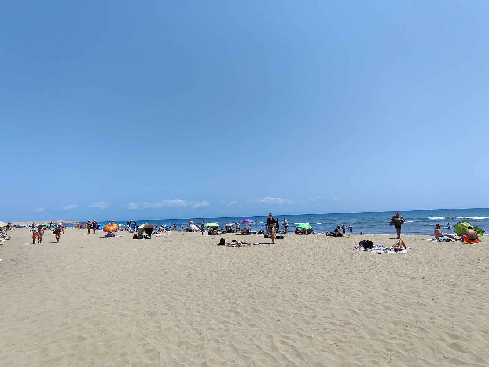 Parasols scattered down the sand in the middle of the afternoon