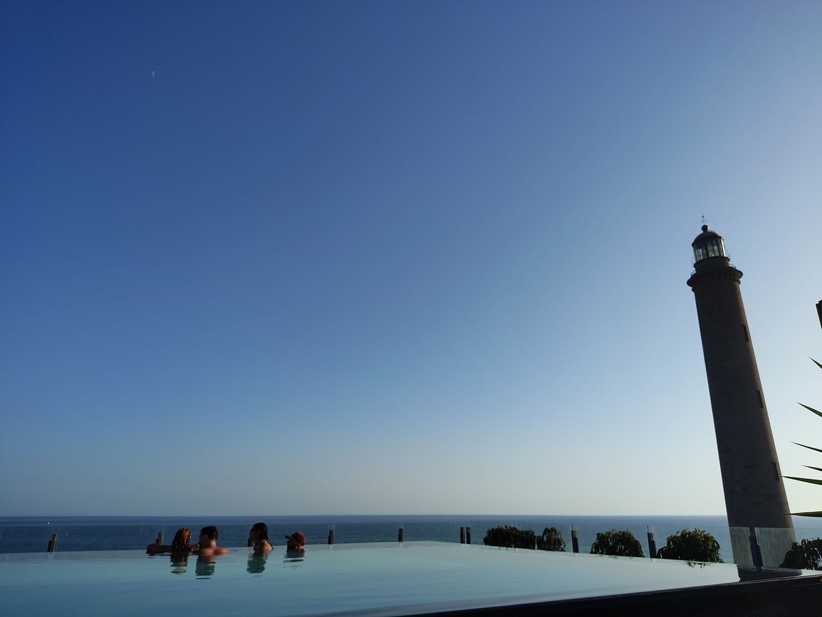 The infinity pool at Hotel Faro, a Lopesan Collection Hotel — the Maspalomas lighthouse right beside it, which is where the hotel gets its name