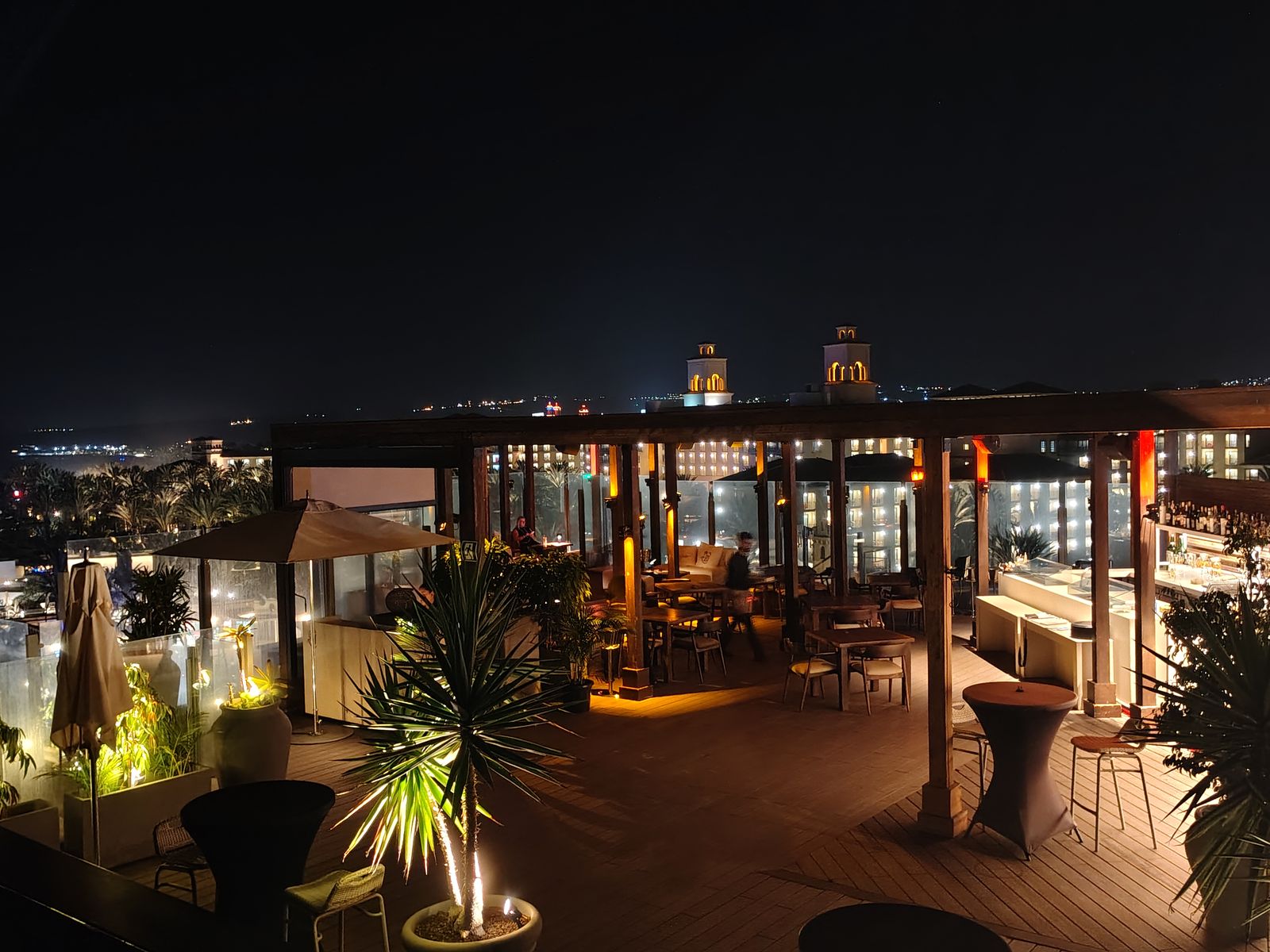 The rooftop bar at Hotel Faro, a Lopesan Collection Hotel, looking back over the resorts after dark
