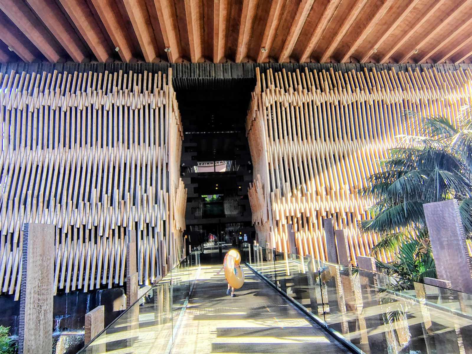 Walking in to Lopesan Baobab between the timber walls — someone ahead with a rubber ring, which tells you what the day holds