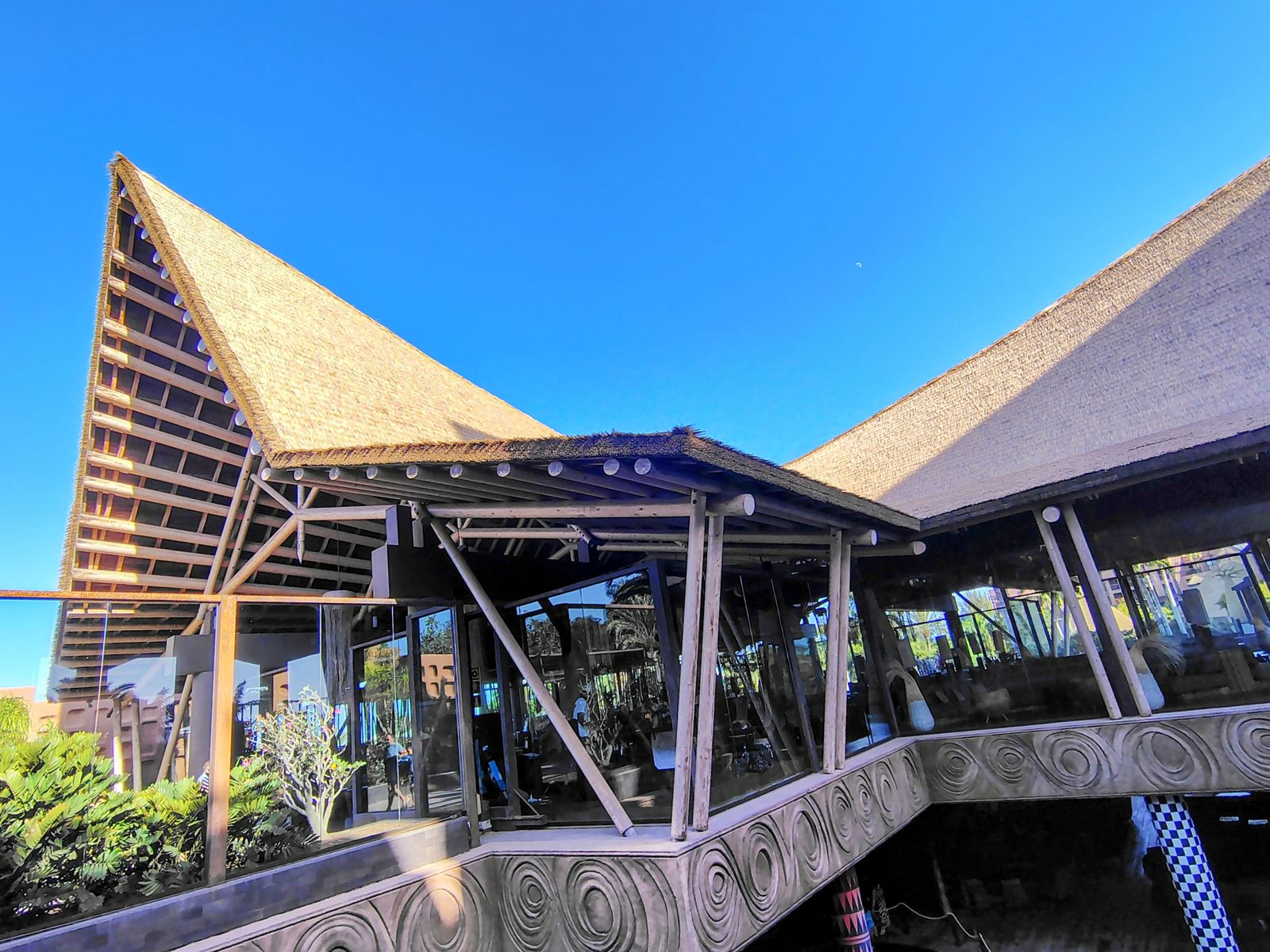 The thatched roofline at Lopesan Baobab, carved concrete and glass beneath it