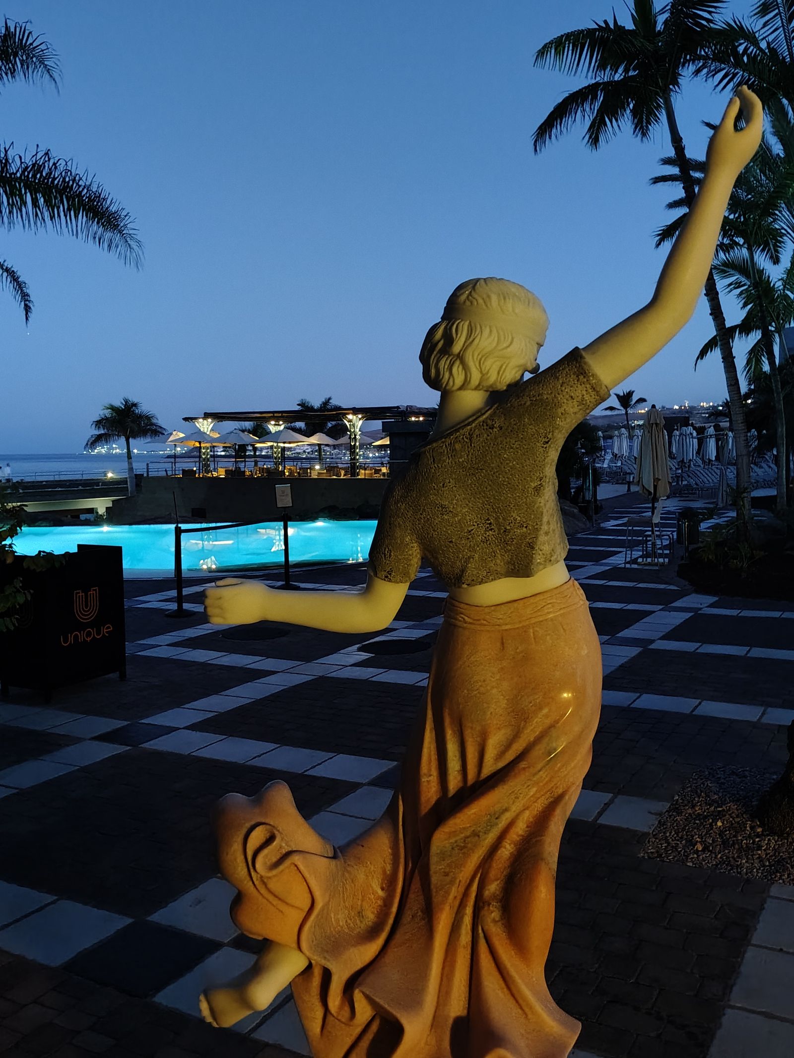 A gilded figure against the dawn, the Lopesan pool still empty