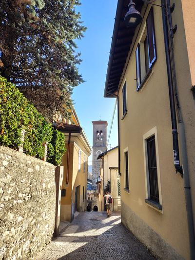 An alley climbing away from the water, bell tower at the top of it