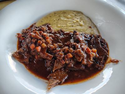Braised beef at a village trattoria — the food here is heavier than the scenery suggests