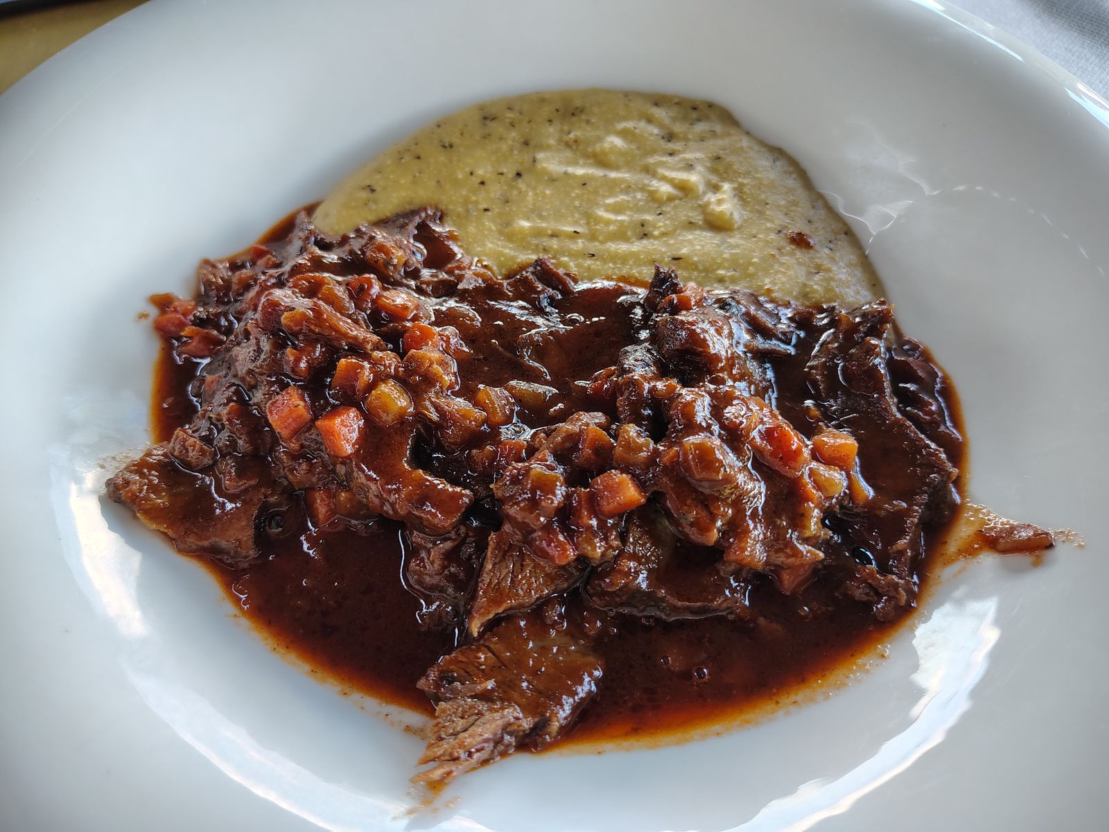 Braised beef at a village trattoria — the food here is heavier than the scenery suggests