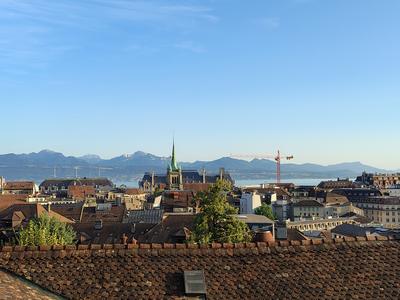 Lausanne cathedral on the ridge, seen across the rooftops — Lake Geneva