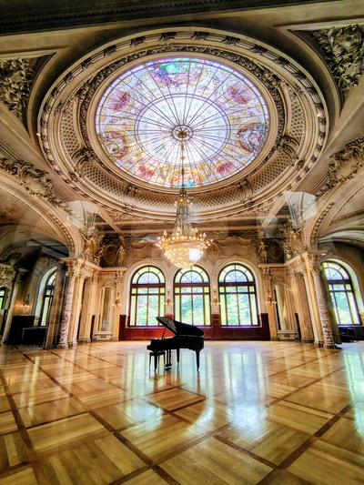 A concert hall under its rose window, piano waiting — Lausanne