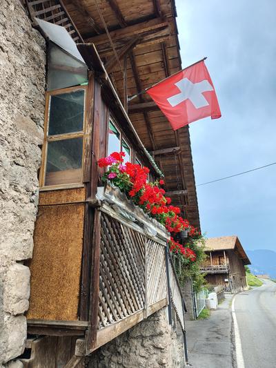 Geraniums and a flag on a chalet balcony, which is not a cliché if it is simply there