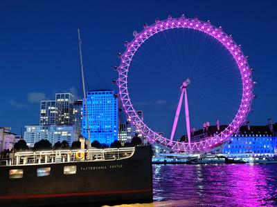 The London Eye lit pink after dark, the Tattershall Castle moored below it <strong>Our own photograph of London, not of the hotel.</strong>