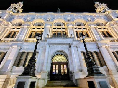 A white Victorian facade lit up at night on the Embankment near Temple