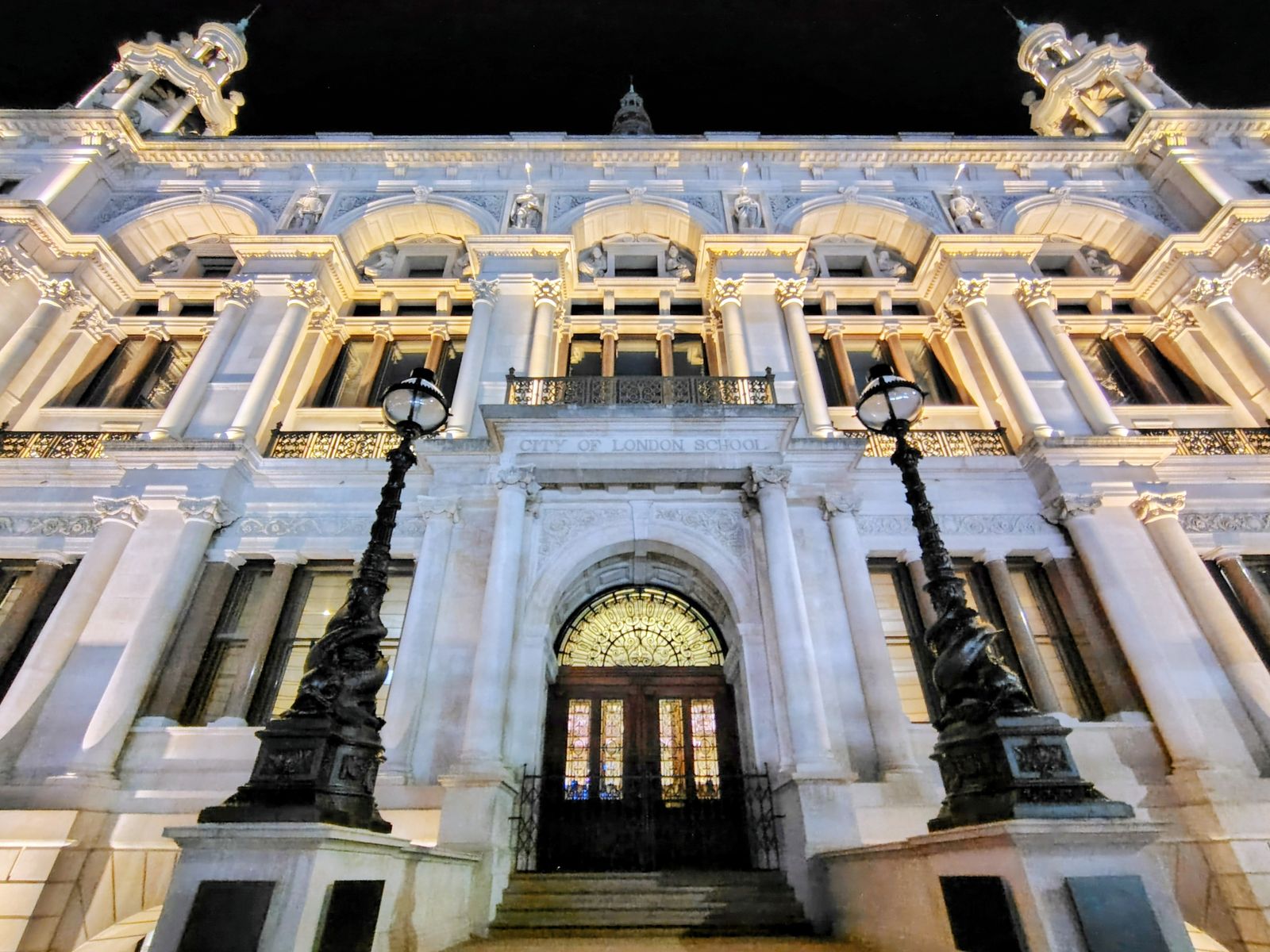 A white Victorian facade lit up at night on the Embankment near Temple