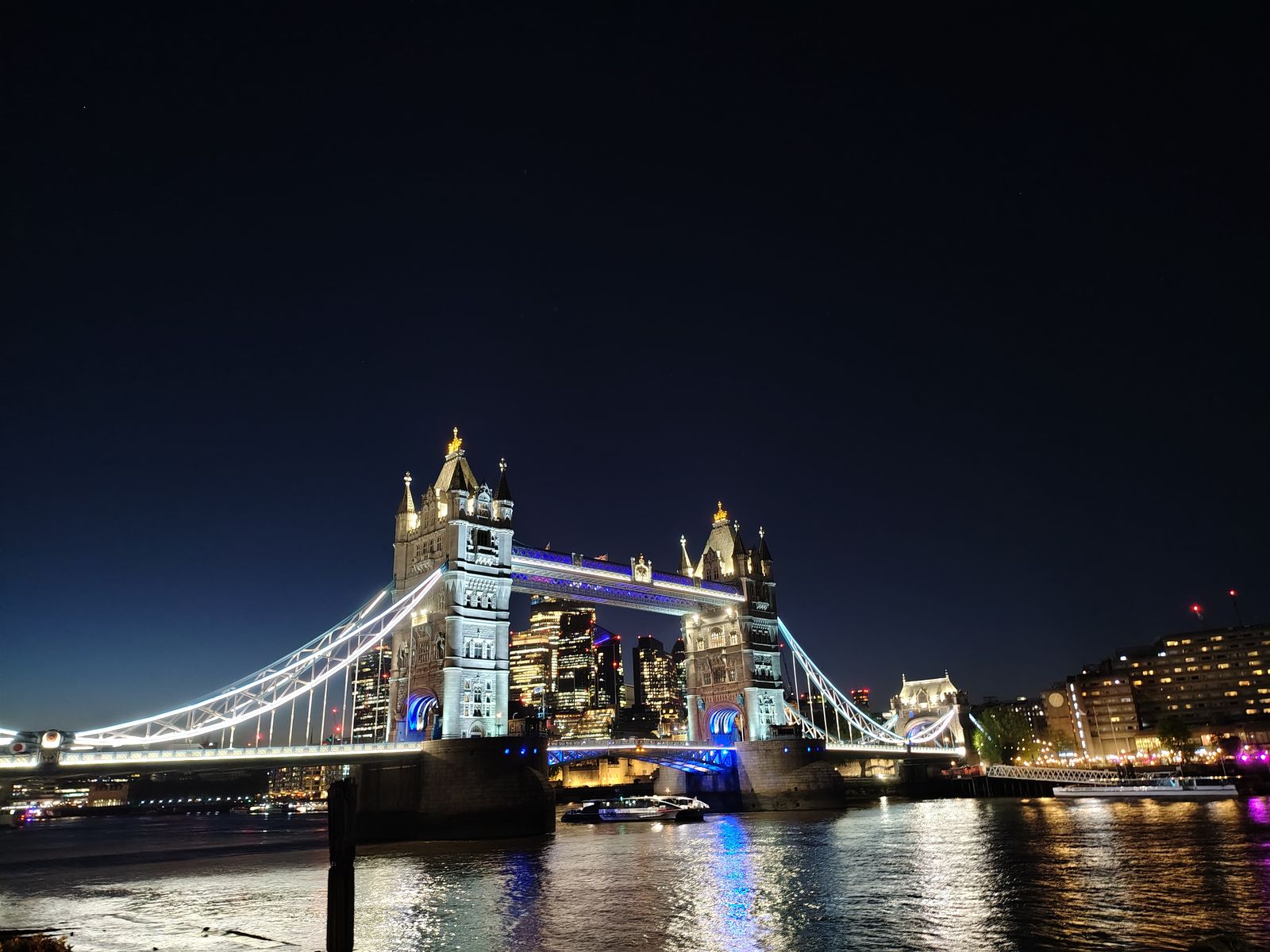 Tower Bridge lit up across the river at night