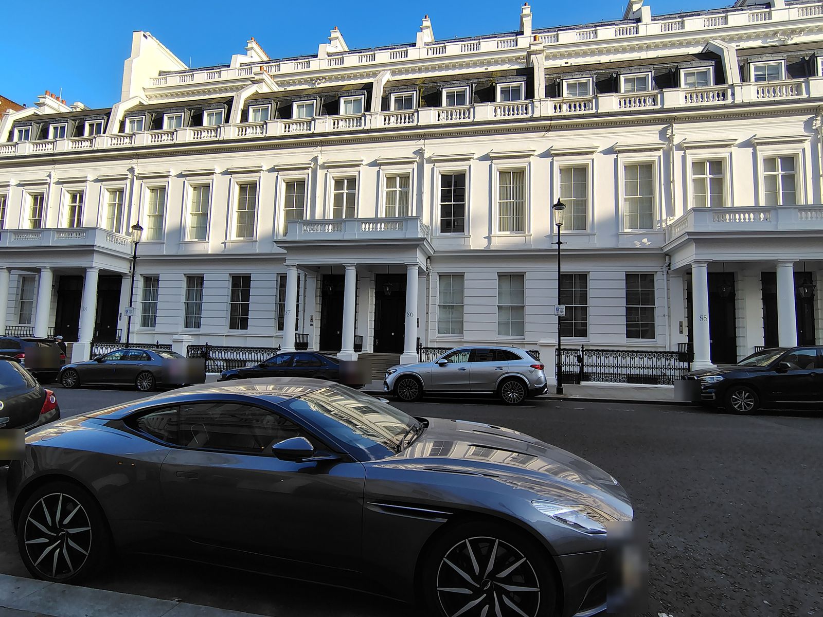 A stucco terrace in Bayswater, an Aston Martin in front