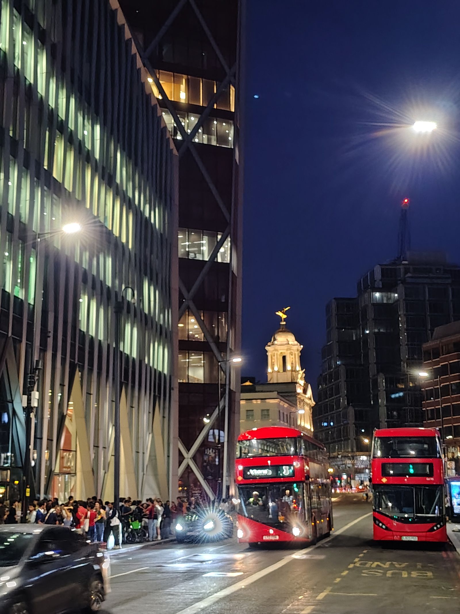 Red buses on Victoria Street under the night sky