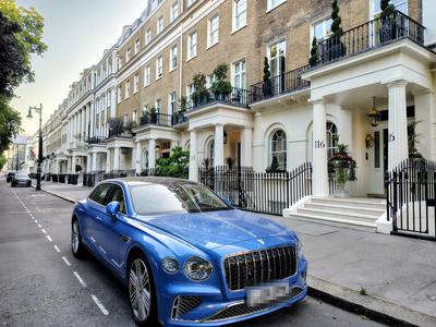 A Belgravia terrace in the evening — white stucco, black railings and something expensive at the kerb — London