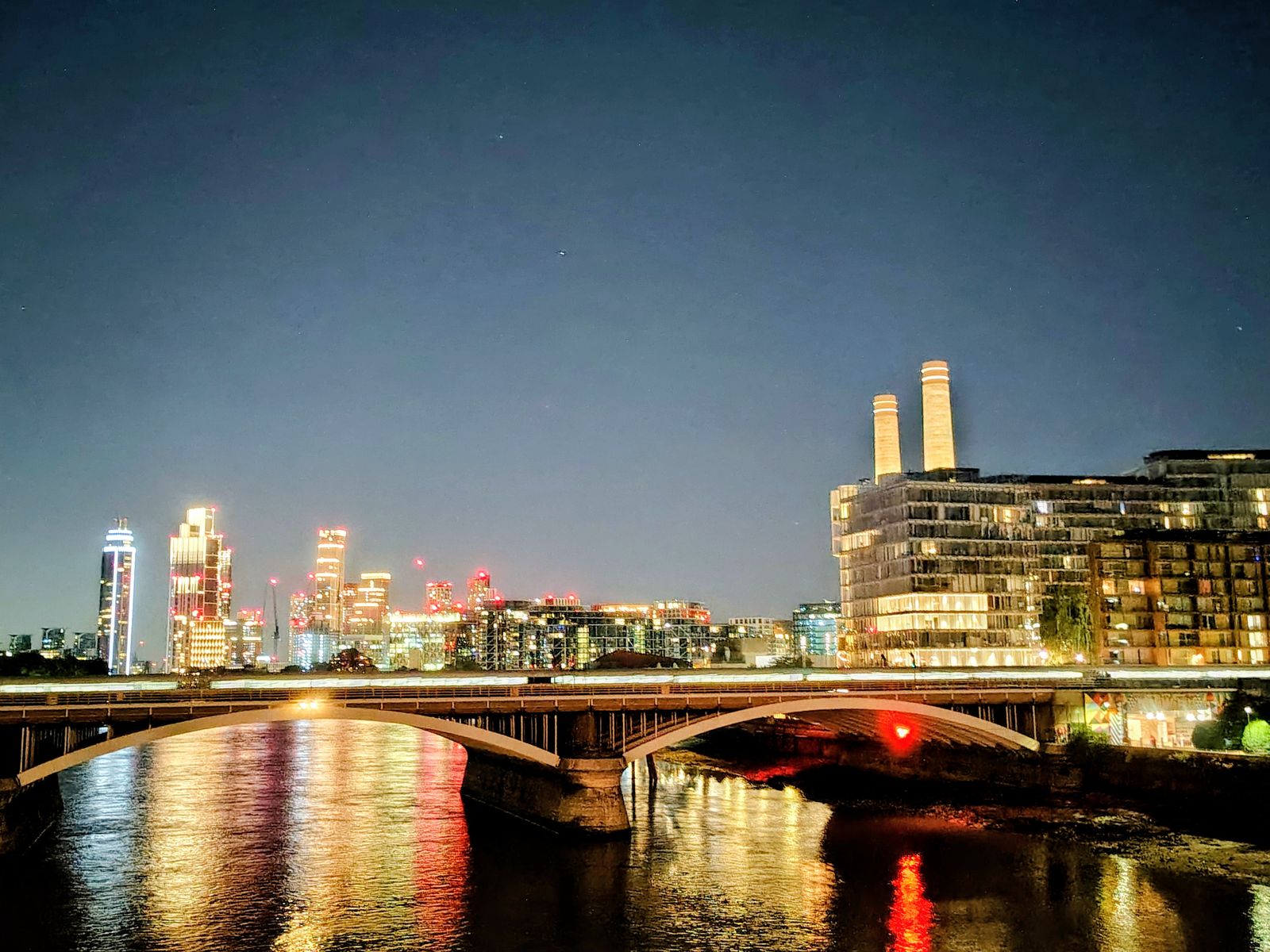 Battersea Power Station and the Nine Elms towers reflected in the Thames after dark