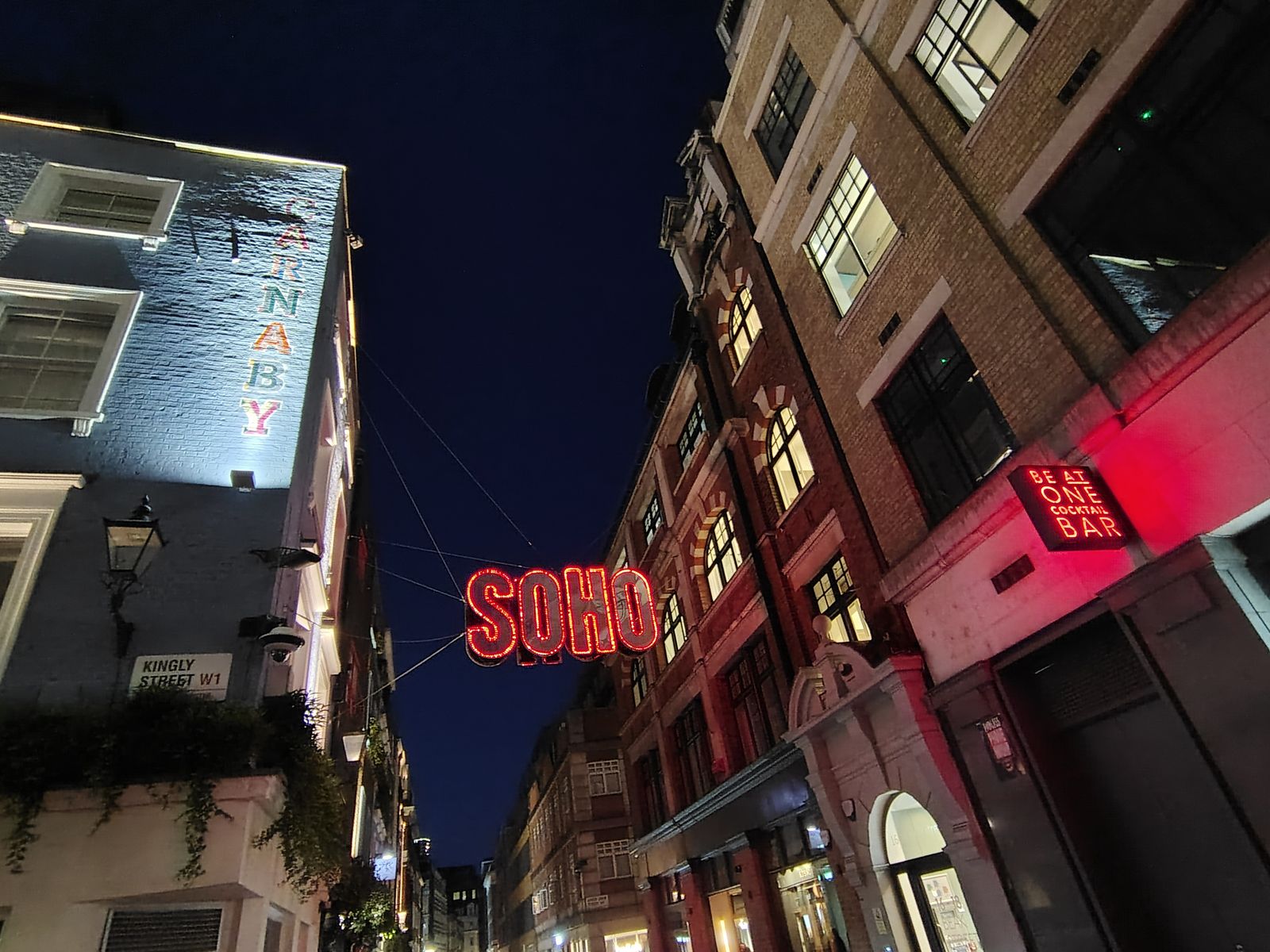Kingly Street off Carnaby, the Soho sign lit red after dark