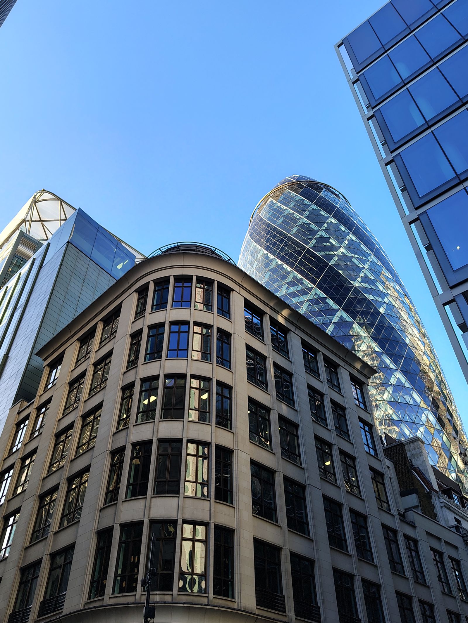 The Gherkin rising behind an old City office block