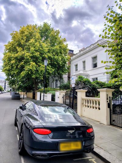 A white villa on a Notting Hill street, a Bentley at the kerb