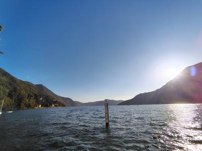 Lake Como in full sun off Torno, the mooring post marking the shallows.
