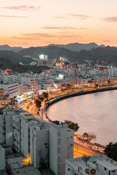 The Muttrah Corniche curving round the harbour at dusk — Oman